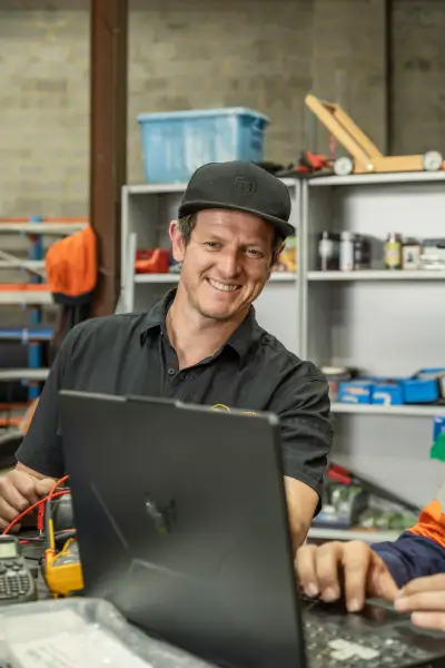 egh-pic-man-black-shirt-cap-desk-smiling-2x3-1707x2560.webp